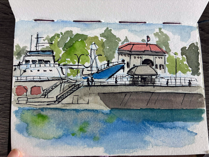 Ink and watercolor painting of the Ballard locks, facing the Carl S. English garden. There is a Flicka boat passing through the locks